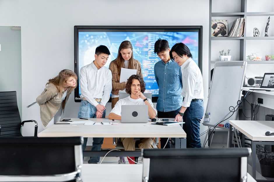 google ads saas — Diverse team collaborating on a software project in a contemporary office setting.