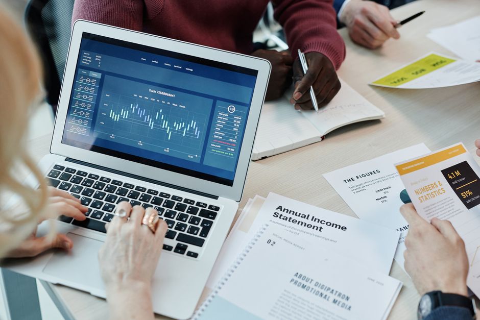 lookalike vs interest targeting — Business professionals analyzing financial data on a laptop during a meeting. Charts a