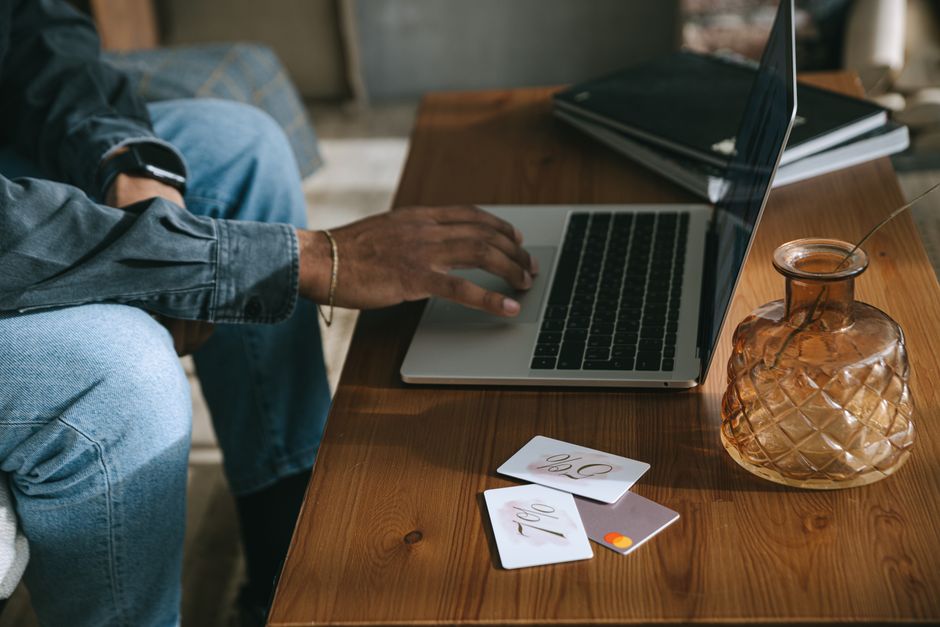 affiliate marketing ร้านค้า — Person shopping online using a laptop with discount cards placed on a wooden table.
