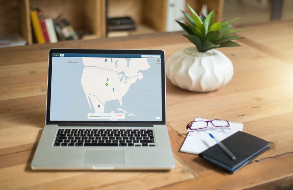 consent mode v2 — A laptop displaying VPN software sits on a wooden desk with a notepad and plant offering a secure work