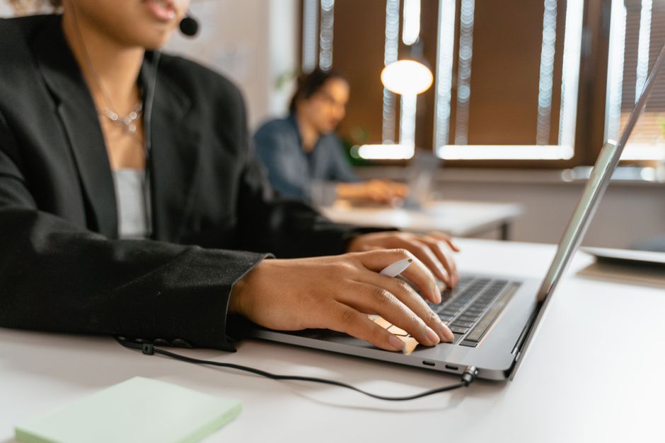 crm data hygiene — Call center agents working on laptops in a modern office setup.