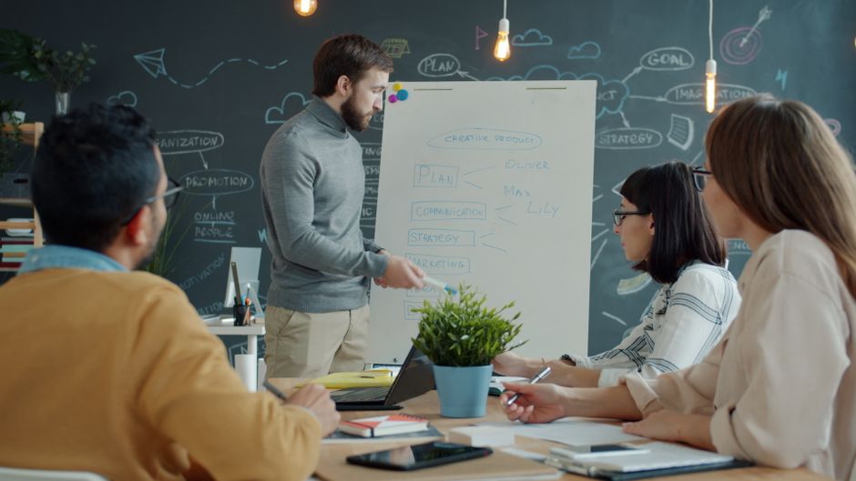 cta copywriting — Team in a modern office setting discussing a creative project strategy.