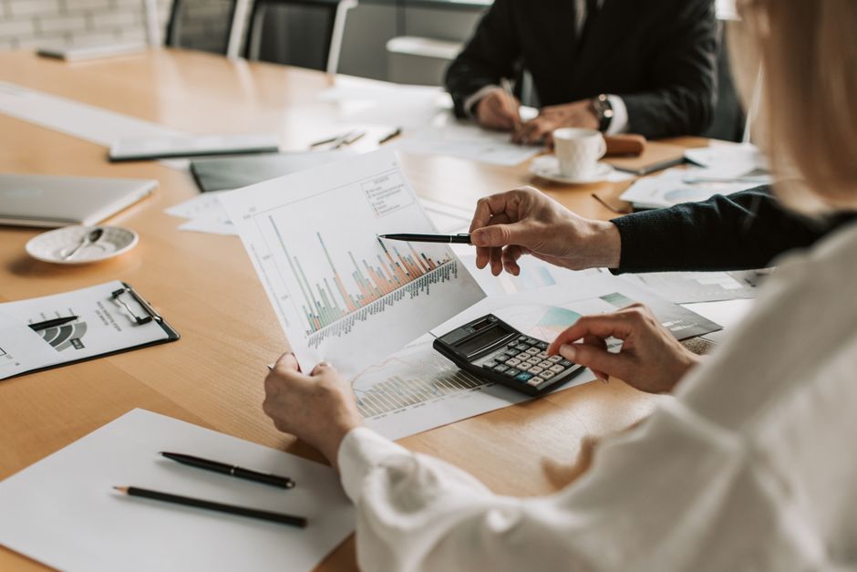 ga4 funnel — Professionals reviewing financial graphs and charts during a meeting.