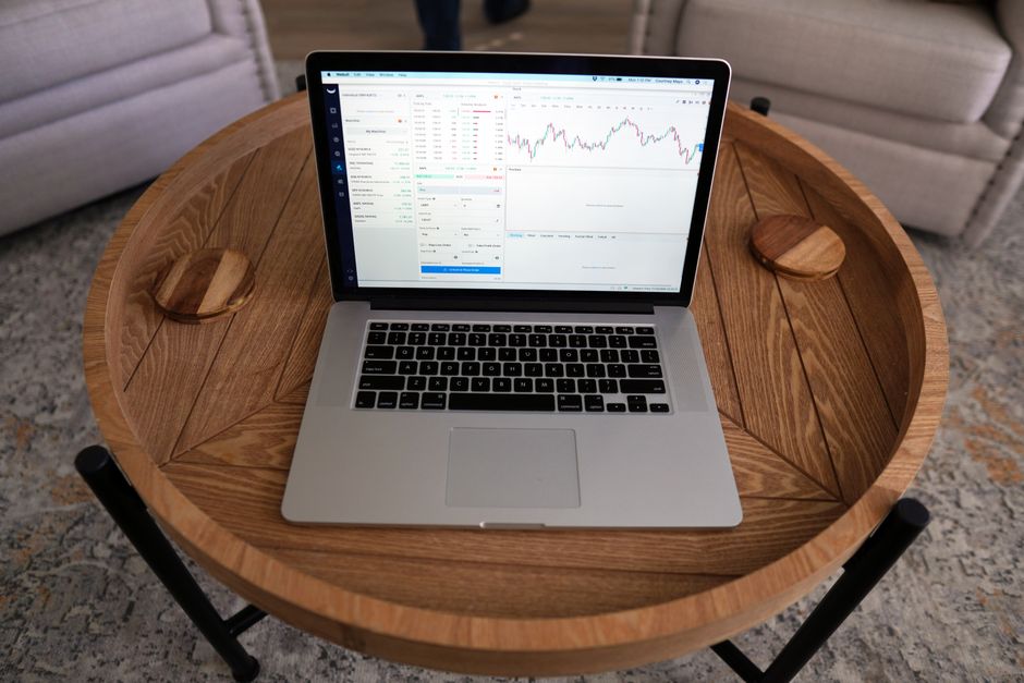 gtm advanced — Close-up of a laptop displaying trading charts on a stylish wooden table, ideal for financial themes.