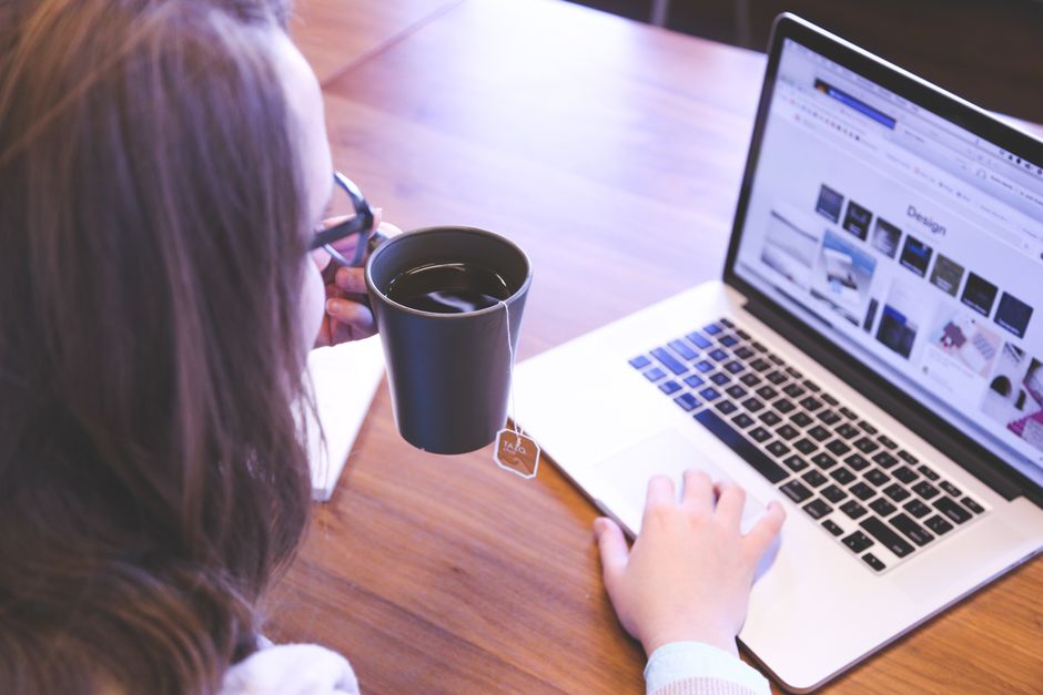 heatmap tool — A woman enjoys coffee while browsing the web on a laptop at a home office desk.