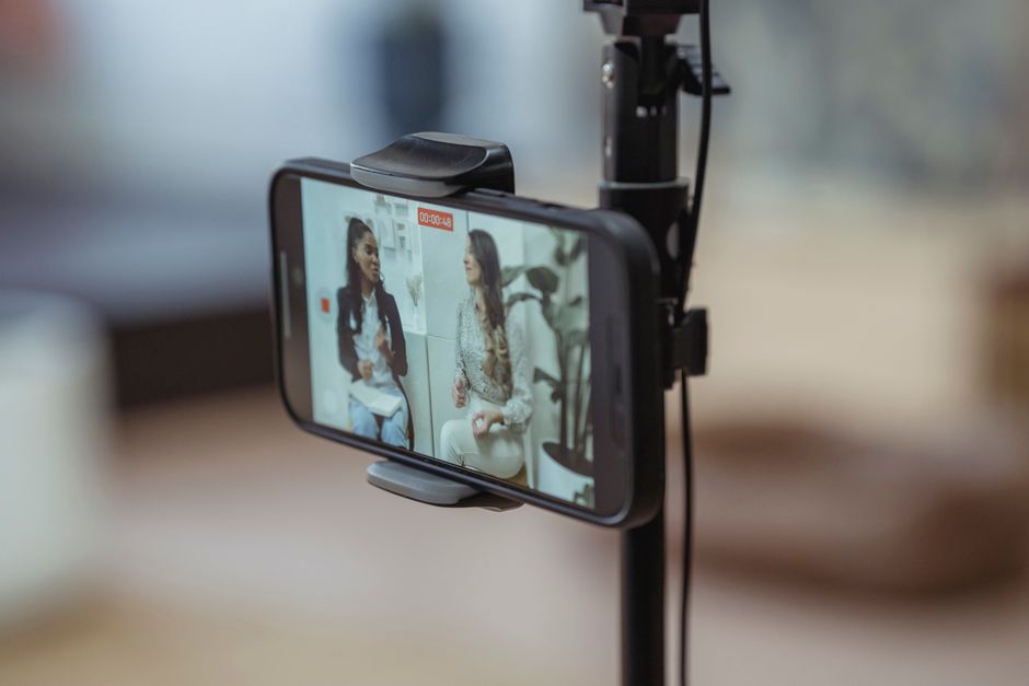 instagram reels ads — Modern smartphone on tripod recording video of content stylish women having friendly conversation