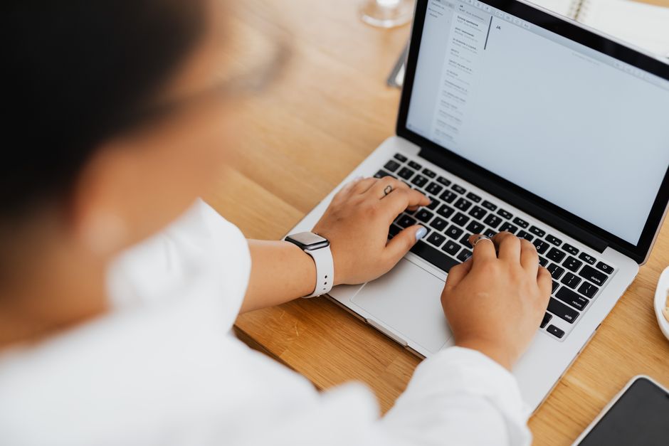 klaviyo vs mailchimp ไทย — High angle shot of a person typing on a laptop, focused on hands and keyboard.