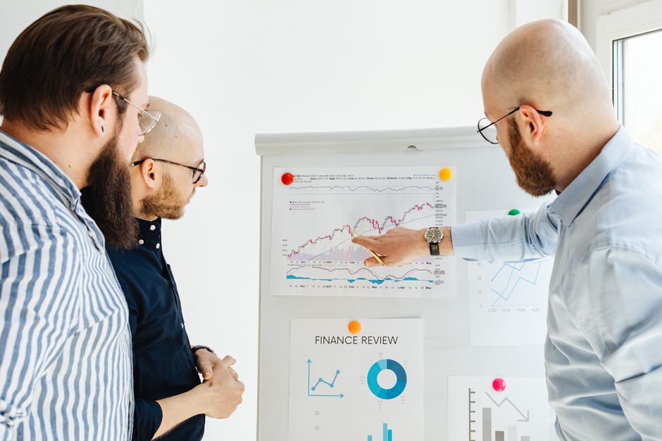 วัด brand awareness — Business team reviewing financial charts during a strategy meeting indoors.