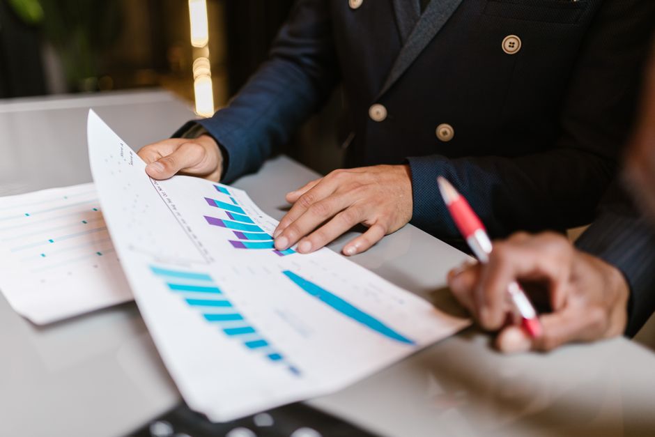 privacy analytics — Close-up of professionals reviewing financial graphs at a business meeting.