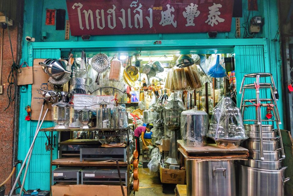 local seo คือ — Vibrant display of assorted kitchenware in a bustling street market shop with a turquoise facade.