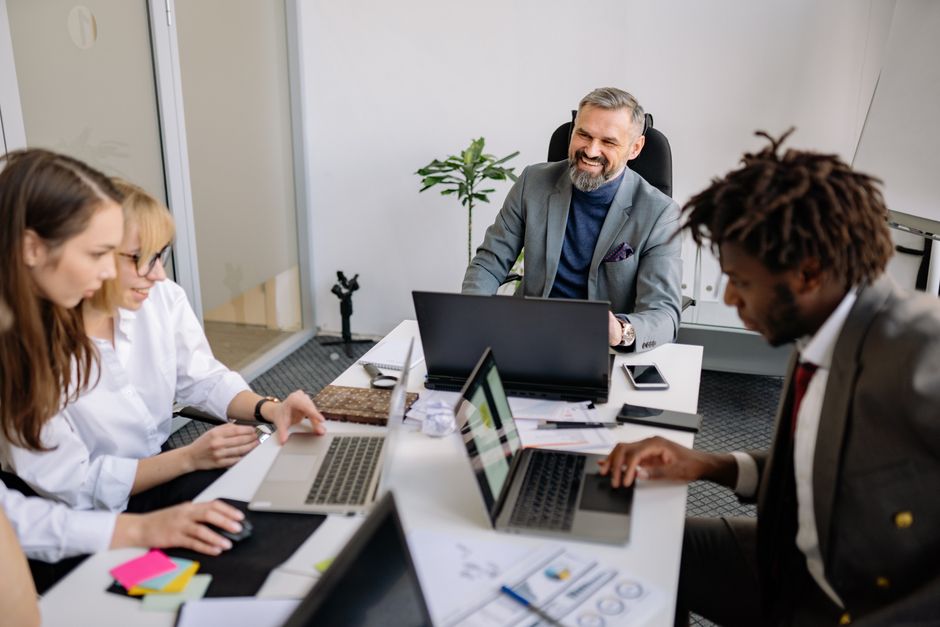 workflow automation — A diverse team of professionals engaged in a collaborative meeting in a modern office setting.