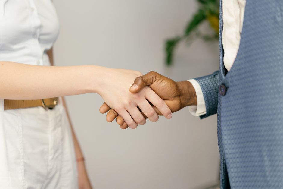 b2b referral program — Close-up of a professional handshake symbolizing agreement and partnership in business.