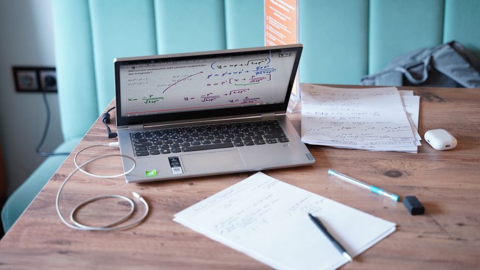 facebook ads library — A creative workspace in Isparta, Türkiye with a laptop and mathematical documents on a wooden des
