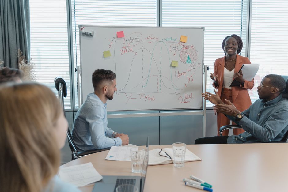 ideal customer profile — Multicultural team discussing strategies in a conference room with a whiteboard presentation.