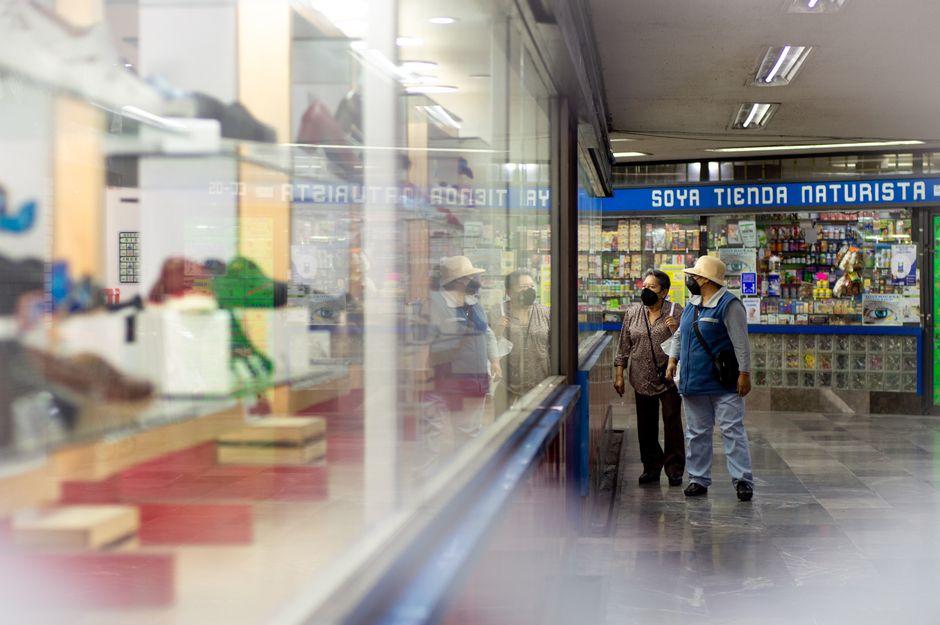 local inventory ads — Adults wearing masks shop indoors at a marketplace, reflective display in view.
