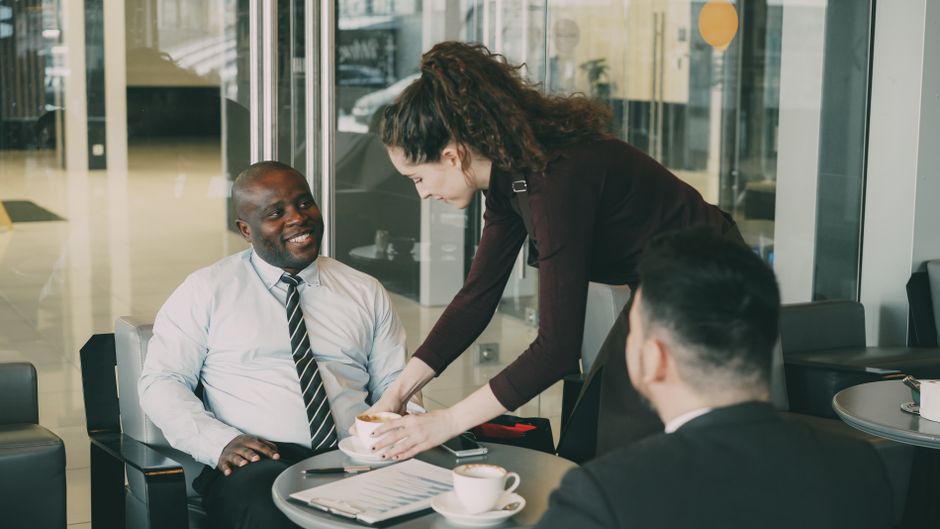 nps b2b — Business professionals enjoying coffee during a casual meeting at a café.